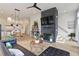 Bright, open-concept living room featuring a modern chandelier and a striking brick fireplace at 100 5Th St, Fayetteville, GA 30214