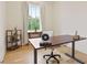 Bright home office with wood floors, large window, and a modern adjustable height desk at 100 5Th St, Fayetteville, GA 30214