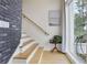 A staircase featuring wood treads and a light gray brick wall, with a picture hanging on the wall at 100 5Th St, Fayetteville, GA 30214