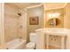 Bathroom with a tiled shower-tub combination, decorative mirror, and classic white fixtures at 195 High Bluff Ct, Duluth, GA 30097