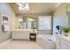 Bright bathroom featuring dual sinks, white cabinets, a soaking tub, and a stylish skylight at 195 High Bluff Ct, Duluth, GA 30097