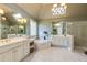 Bright and spacious bathroom featuring dual vanities, a soaking tub, skylights, and a separate glass shower at 195 High Bluff Ct, Duluth, GA 30097