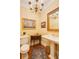 Charming powder room with a pedestal sink, elegant lighting, decorative mirror, and wood flooring at 195 High Bluff Ct, Duluth, GA 30097