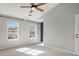 Bedroom featuring neutral carpeting, two windows, and a ceiling fan for comfort at 5545 Mountain Top Pl, Cumming, GA 30041