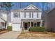 Charming two-story home featuring gray siding, a covered front porch, and an attached single car garage at 5545 Mountain Top Pl, Cumming, GA 30041