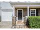 Close-up of the front porch with stone accents, black front door, and neatly trimmed hedges at 5545 Mountain Top Pl, Cumming, GA 30041