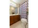 Cozy bathroom features a vanity with cabinets and a toilet with a patterned shower curtain at 1088 Raleigh Way, Lawrenceville, GA 30043