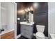 Stylish powder room featuring black accent wall, gray vanity, and modern lighting fixture at 1549 Beecher Sw St, Atlanta, GA 30310