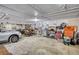 Spacious garage featuring a concrete floor, shelving, tools, and a parked car at 744 Hampton Locust Grove Rd, Hampton, GA 30228