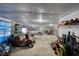 Large garage with a concrete floor containing vehicles, yard equipment, and tools at 744 Hampton Locust Grove Rd, Hampton, GA 30228