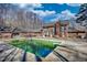Backyard with a large pool and a brick house in the background under a cloudy sky at 744 Hampton Locust Grove Rd, Hampton, GA 30228