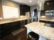 Bright kitchen featuring granite countertops, stainless steel appliances, dark cabinetry and a kitchen island at 1365 Willis Lake Dr, Kennesaw, GA 30152