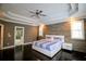 Spacious bedroom with a wood accent wall, tray ceiling, ceiling fan and ensuite bathroom at 1365 Willis Lake Dr, Kennesaw, GA 30152