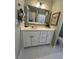 Bright bathroom with a decorative mirror, cream cabinets, and white tiled floor at 1580 Reids Ferry Way, Marietta, GA 30062