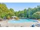 Large community pool with ample lounge chairs and umbrellas surrounded by lush landscaping and mature trees at 1580 Reids Ferry Way, Marietta, GA 30062