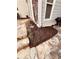 A stone patio featuring a garden with dark mulch, a gas grill, and access to the home's entrance at 1580 Reids Ferry Way, Marietta, GA 30062