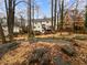 Spacious backyard with mature trees, landscaping, and a view of the home's exterior at 1935 Wenton Pl, Lawrenceville, GA 30044