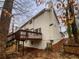 Side view of home with wooden deck and chimney on a cloudy day in wooded location at 1935 Wenton Pl, Lawrenceville, GA 30044