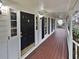 Inviting covered front porch with dark door, sidelights, and a varnished wood porch at 1935 Wenton Pl, Lawrenceville, GA 30044