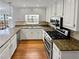 Updated kitchen features granite counters, stainless steel appliances, and white cabinets at 1935 Wenton Pl, Lawrenceville, GA 30044