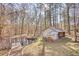 Scenic view of a pond with a small dock, surrounded by trees and a small shed with stacked wood at 2194 Highway 20 E., Mcdonough, GA 30252