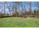 Expansive backyard with a fire pit and seating area, surrounded by mature trees and a well-maintained lawn at 1322 Elmhurst Circle Se Cir, Atlanta, GA 30316