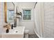 Stylish bathroom with white subway tiles, floating shelves, modern sink, and a shower-tub combo at 1322 Elmhurst Circle Se Cir, Atlanta, GA 30316