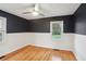 Bright bedroom featuring hardwood floors, two-toned walls, modern ceiling fan, and windows with outdoor view at 1322 Elmhurst Circle Se Cir, Atlanta, GA 30316