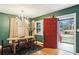 Charming dining room featuring a modern chandelier, green walls, and an inviting red door, creating a unique ambiance at 1322 Elmhurst Circle Se Cir, Atlanta, GA 30316