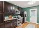 Cozy kitchen with dark cabinets, green walls, and stainless steel appliances, designed for both functionality and style at 1322 Elmhurst Circle Se Cir, Atlanta, GA 30316