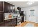 Well-lit kitchen featuring dark wood cabinets, granite countertops, and stainless steel appliances at 1322 Elmhurst Circle Se Cir, Atlanta, GA 30316