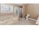 Bathroom featuring a soaking tub, separate shower, tile floors, and bright windows at 4900 Raquet Ct, Duluth, GA 30096