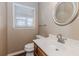 Cozy bathroom with a circular mirror, single sink, and window at 4900 Raquet Ct, Duluth, GA 30096