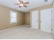 Neutral carpeted bedroom features a ceiling fan and bright window at 4900 Raquet Ct, Duluth, GA 30096