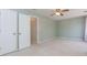 Spacious bedroom with neutral carpet, ceiling fan, and adjacent doorway at 4900 Raquet Ct, Duluth, GA 30096