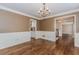 Formal dining room with hardwood floors, elegant wainscoting, and access to the kitchen at 4900 Raquet Ct, Duluth, GA 30096