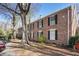 Side view of a brick condo building with black shutters and mature trees at 6700 Roswell Rd # 11B, Atlanta, GA 30328