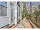 A home's side exterior featuring white siding, brick foundation, and access to backyard at 6700 Roswell Rd # 11B, Atlanta, GA 30328