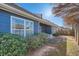 Exterior view of the backyard with blue siding, mature plants, and a patio area at 1756 Hedington Ct, Lawrenceville, GA 30045