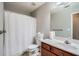 Well-lit bathroom with a modern vanity, a toilet, and a shower with a white curtain at 1756 Hedington Ct, Lawrenceville, GA 30045