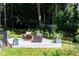 Backyard patio includes outdoor furniture arranged around a fire pit, surrounded by green foliage at 3117 W Roxboro Ne Rd, Atlanta, GA 30324