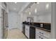 Basement bar area featuring black countertops, white cabinets, and stainless steel appliances at 3117 W Roxboro Ne Rd, Atlanta, GA 30324