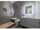 Luxurious bathroom featuring textured gray tiling, a glass-enclosed shower, and a modern floating vanity with a lighted mirror at 3117 W Roxboro Ne Rd, Atlanta, GA 30324