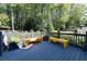 Outdoor deck with gray floors and bright yellow benches surrounded by lush greenery at 3117 W Roxboro Ne Rd, Atlanta, GA 30324