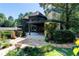 Exterior view of a home with stone chimney, outdoor seating area, and large stone patio at 3117 W Roxboro Ne Rd, Atlanta, GA 30324