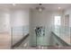 Bright hallway with glass railing overlooking the staircase below, with hardwood floors and white walls at 3117 W Roxboro Ne Rd, Atlanta, GA 30324