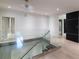 Bright hallway with glass railing overlooking the staircase below, with hardwood floors at 3117 W Roxboro Ne Rd, Atlanta, GA 30324