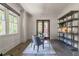 Well-lit home office with a modern bookshelf, a glass-top desk, and a serene view of the outdoors at 3117 W Roxboro Ne Rd, Atlanta, GA 30324