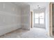 Unfinished room featuring drywall, a window with natural light, and an open doorway at 628 Sandhill Hickory Level Rd, Carrollton, GA 30116