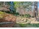 Picturesque backyard showcasing stone steps leading to a tranquil wooded area with mature trees and landscaping at 733 Vinings Estates Se Dr, Mableton, GA 30126